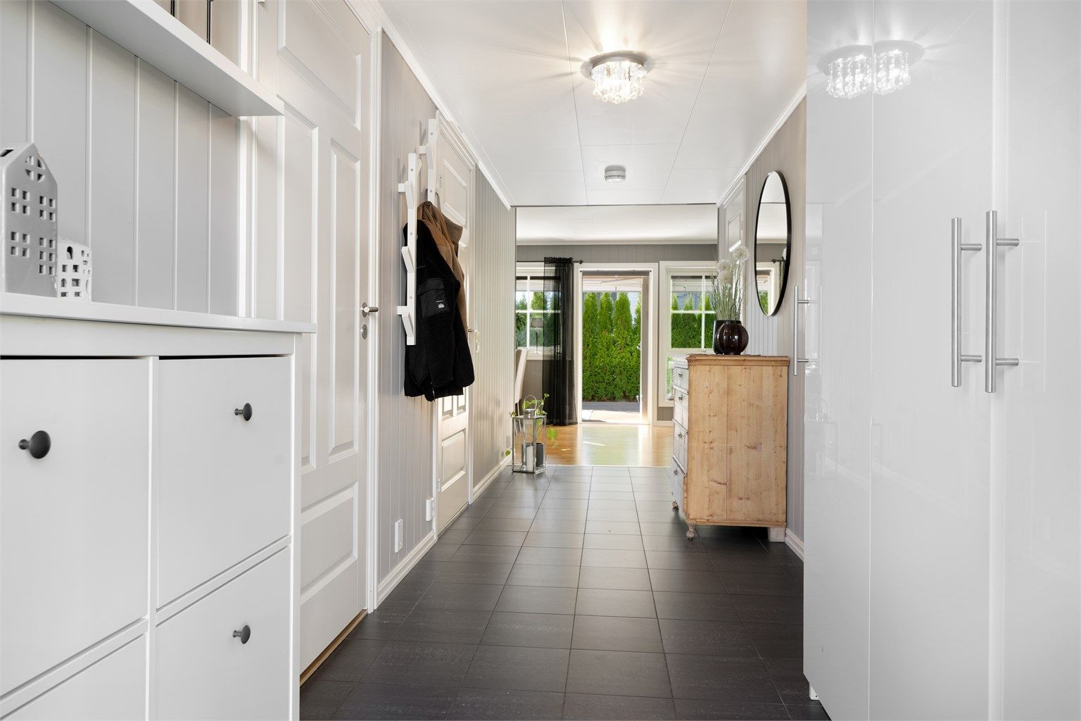 Lys og romslig entré med flislagt gulv og varmekabler. God oppbevaringsplass til sko og yttertøy.