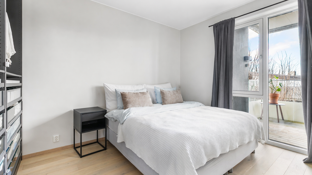 Romlengde på nær 4 meter gir god plass til en dobbeltseng og nattbord på begge sider. Digitalt redigert av KI.