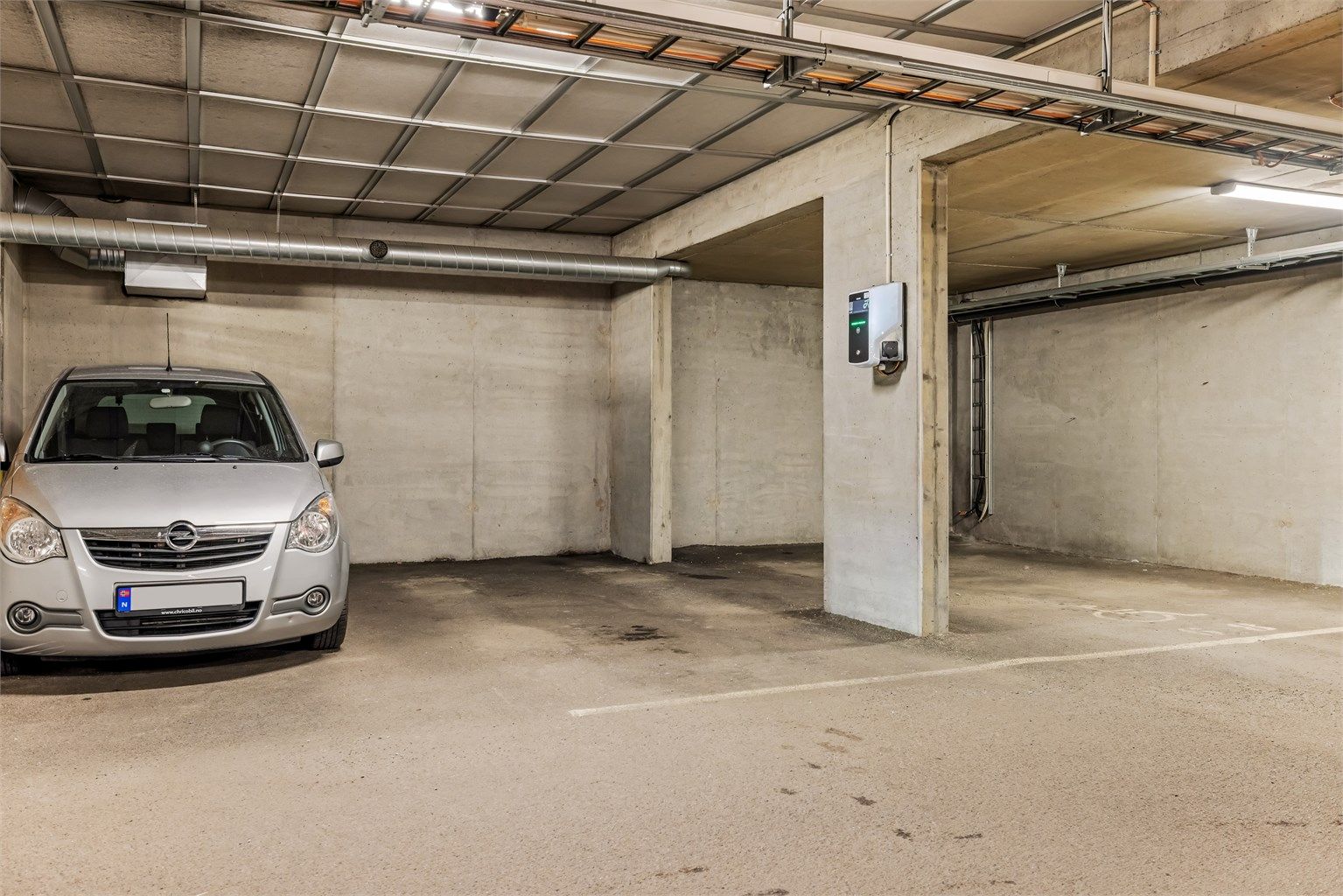 Egen parkeringsplass i felles garasjeanlegg. Det er installert lader for elbil.