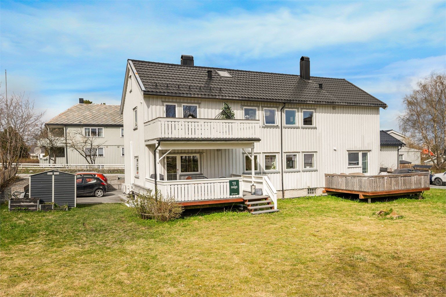 Pen del av firemannsbolig med stor, sørvendt veranda.