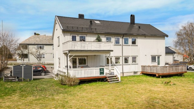 Pen del av firemannsbolig med stor, sørvendt veranda.