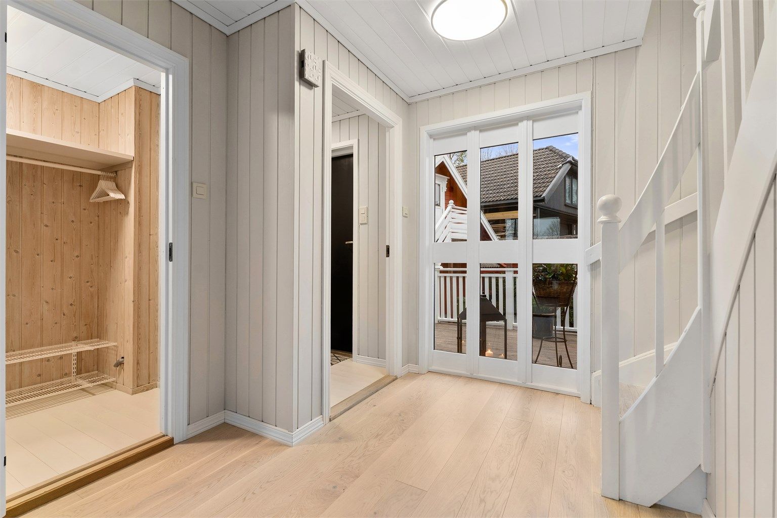 Gang med stor garderobeløsning til venstre i bildet og en sjarmerende trappeoppgang/entré. 