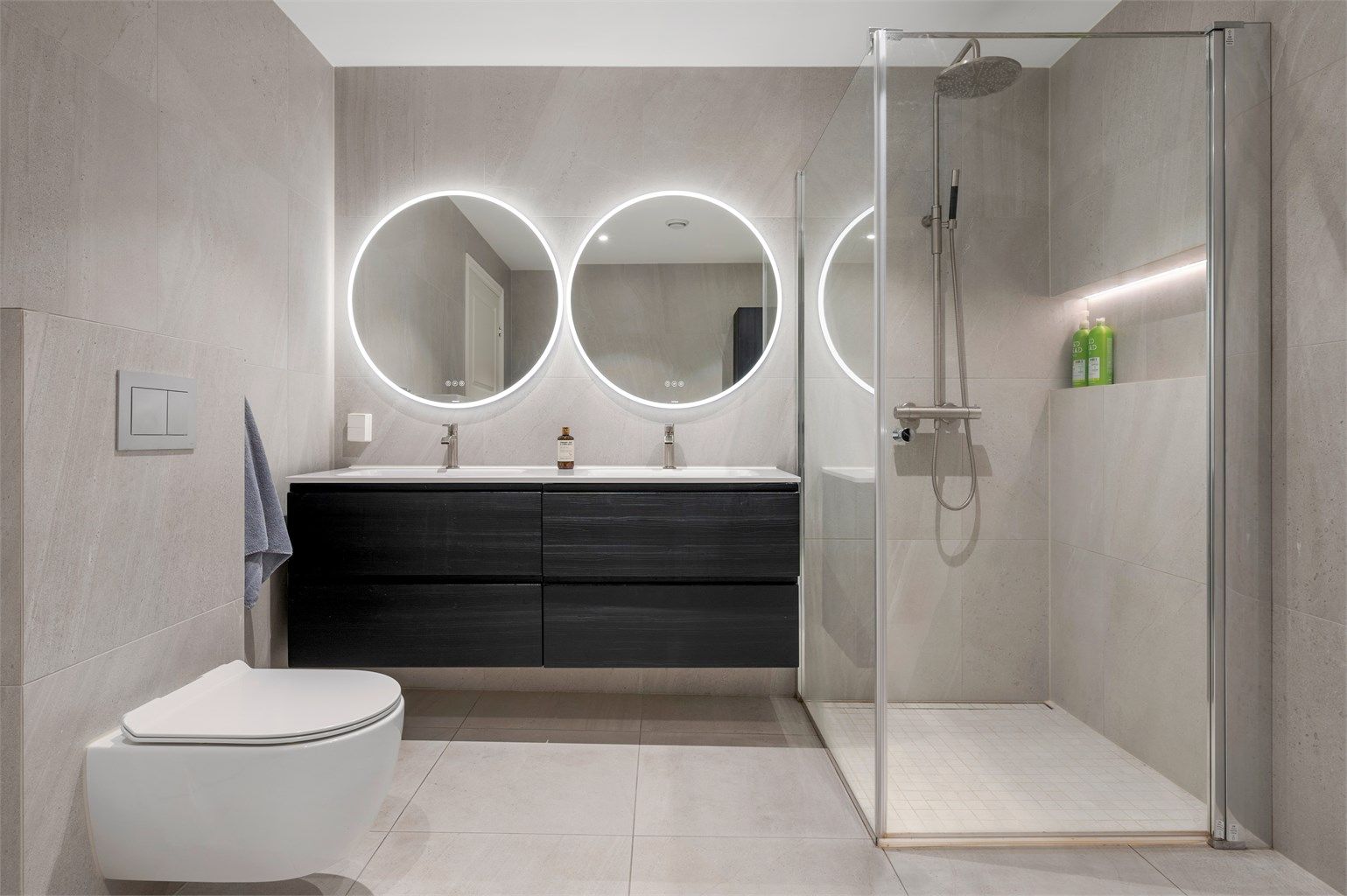 Pent flislagt bad på 8,5 kvm med gulvvarme og downlights i himling. Videre er badet innredet med dobbeltservant med speil og lys, dusjhjørne med regndusj og vegghengt toalett. 
