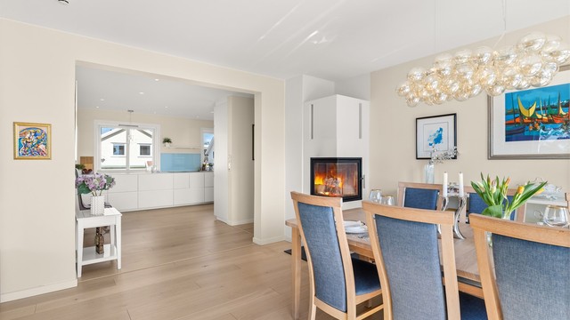 Den åpne passasjen mot kjøkkenet binder oppholdssonene elegant sammen.