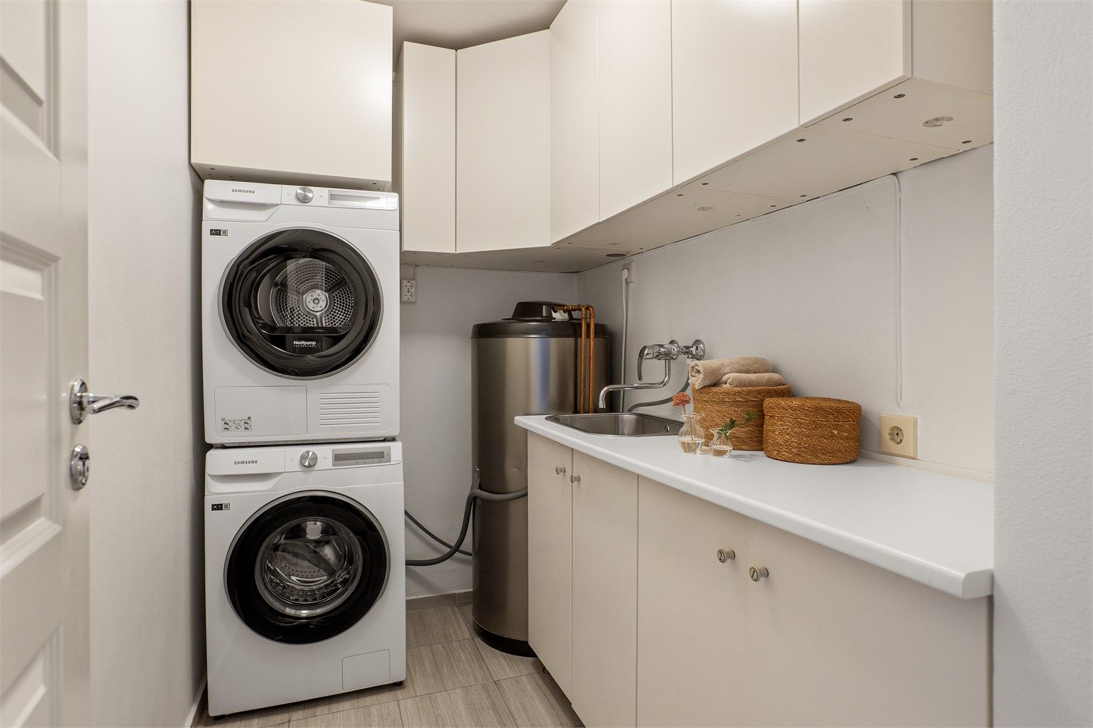 Eget separat vaskerom med opplegg for vaskemaskin og tørketrommel. Rommet har også godt med skap- og benkeplass samt utslagsvask