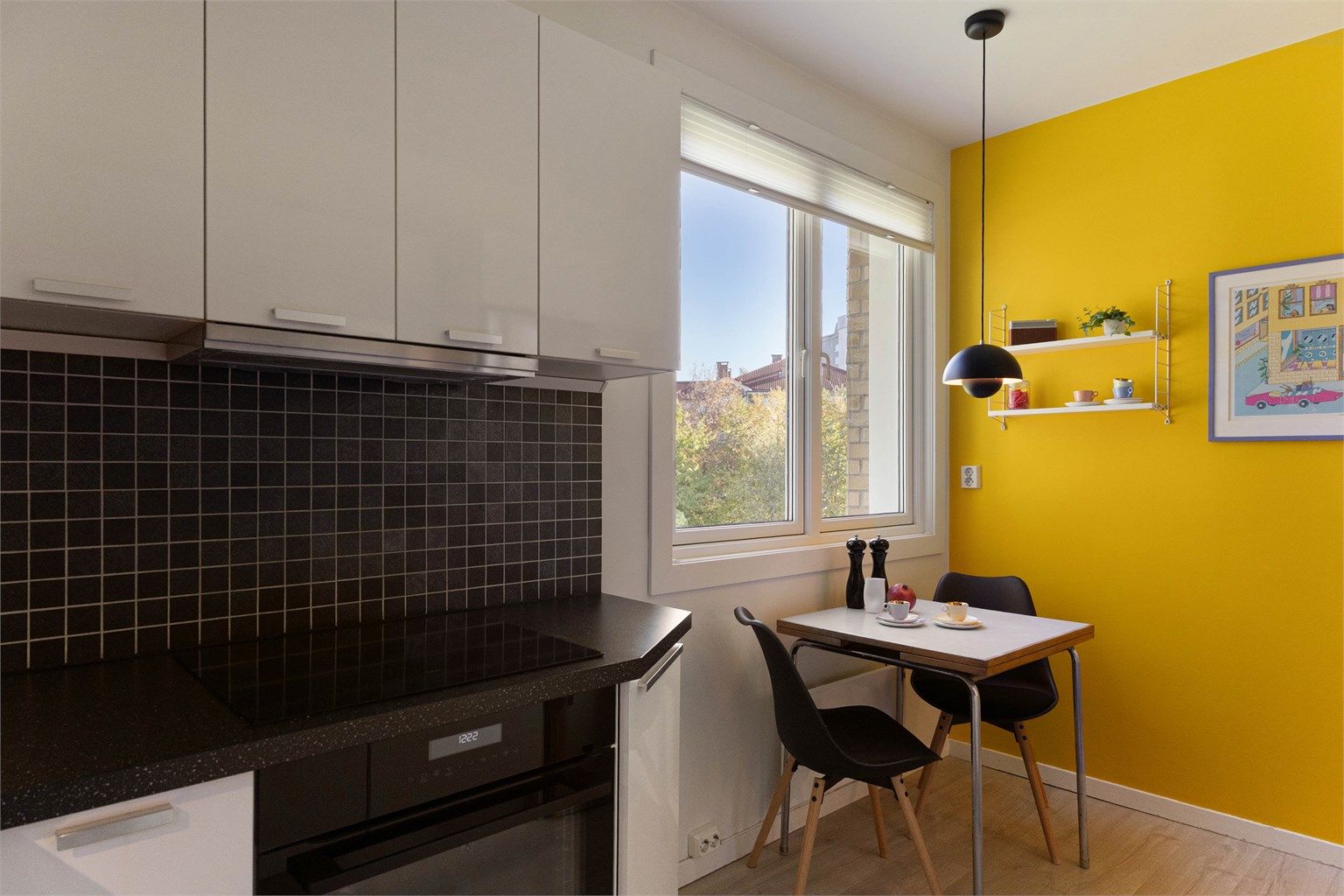 Spisekroken ved vinduet er en liten perle i leiligheten, der den gule kontrastveggen gir en varm og sjarmerende ramme rundt måltidene. Perfekt for en rolig frokost, et hjemmekontor for dagen eller en hyggelig prat over middagsbordet.