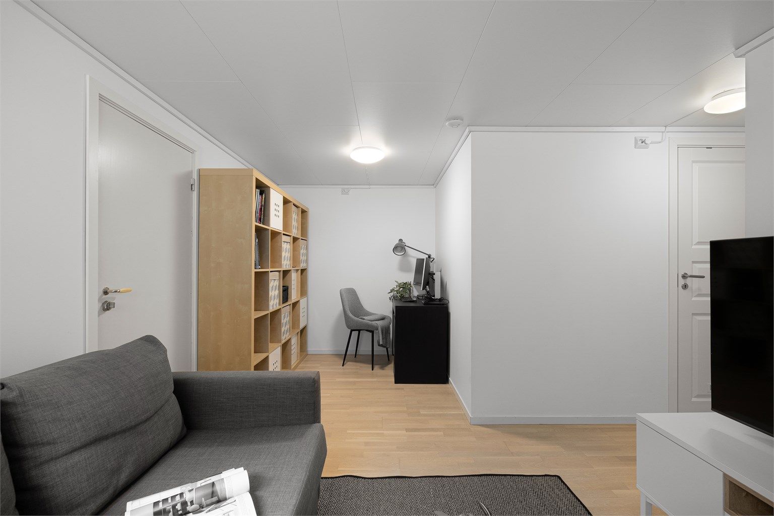 
Kjellerstue med plass til både sofa, tv og en kontorplass.