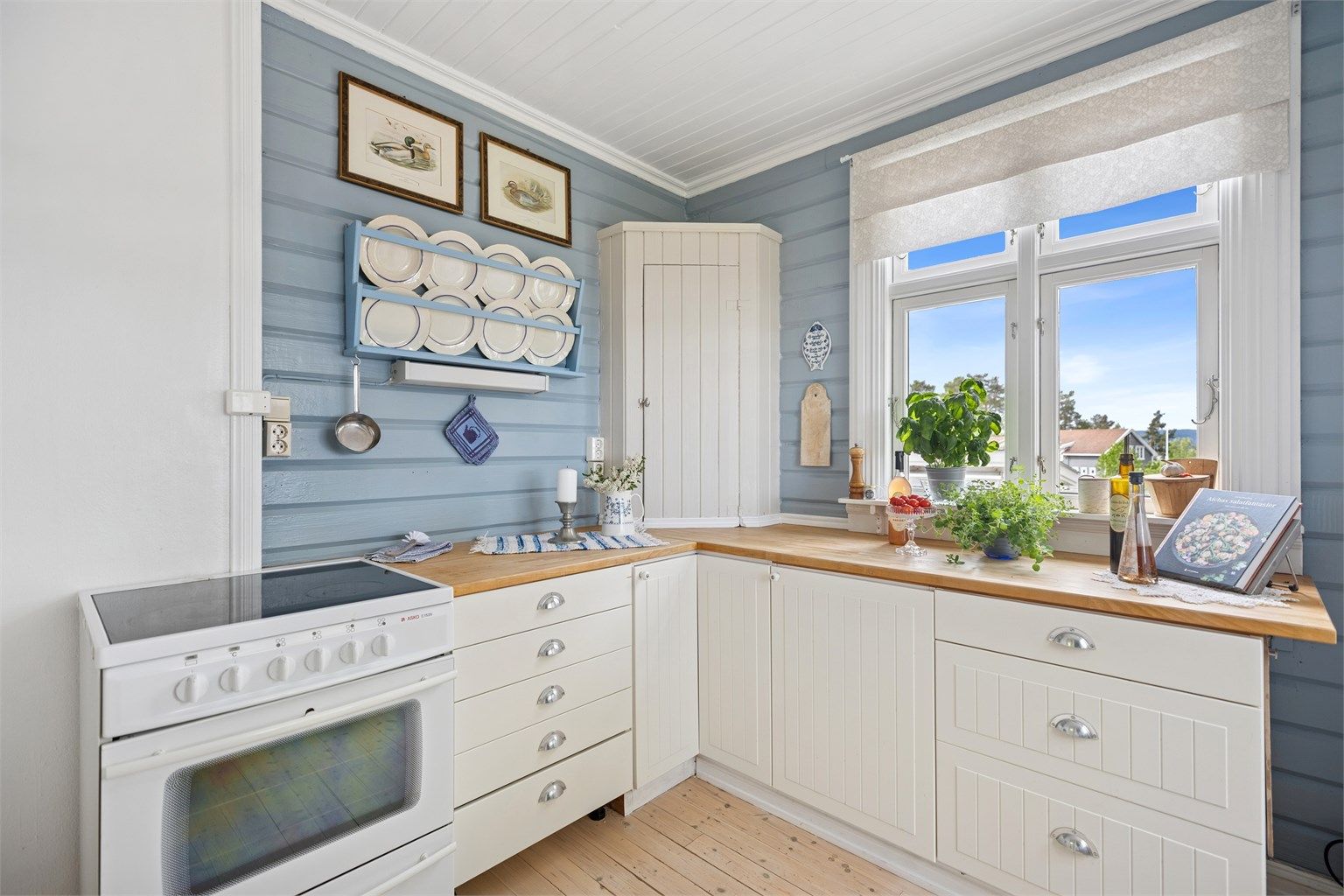 Det er godt med skap- og benkeplass og dette er et hyggelig rom å kokkelere i. Vinduer mot fjorden gir rikelig med naturlig lys inn i rommet