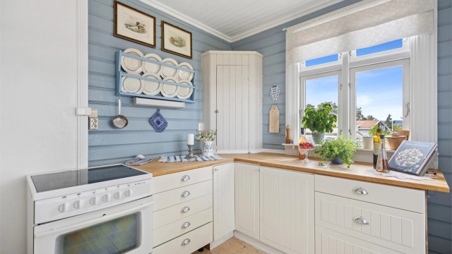 Det er godt med skap- og benkeplass og dette er et hyggelig rom å kokkelere i. Vinduer mot fjorden gir rikelig med naturlig lys inn i rommet