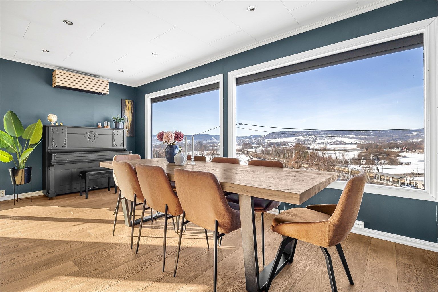 Spisestuen har god plass til langbord og nyter godt av utsikten gjennom store vinduer.