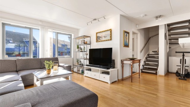 Romslig stue med flere møbleringsalternativer. Her er det plass til sittegruppe og TV-område. Den åpne løsningen mellom stue, spisestue og kjøkken skaper en sosial atmosfære når man er med venner og familie.