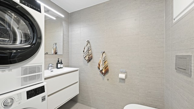 Lekkert og flislagt bad med gulvvarme. Plass og opplegg til vaskemaskin og tørketrommel. Badet er fra byggeår. Det ble i 2018 lagt flis på flis, samt ny servant, armatur og dusjarmatur