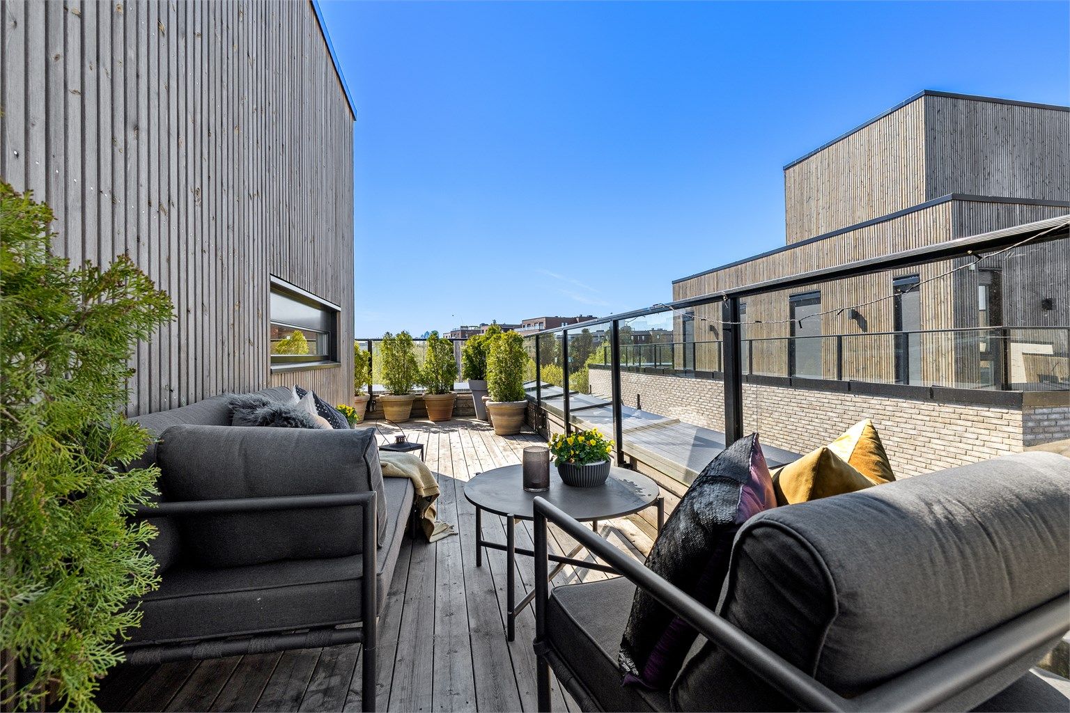 Terrassen er pent anlagt med tredekke og rekkverk i glass for å maksimere utsikten.