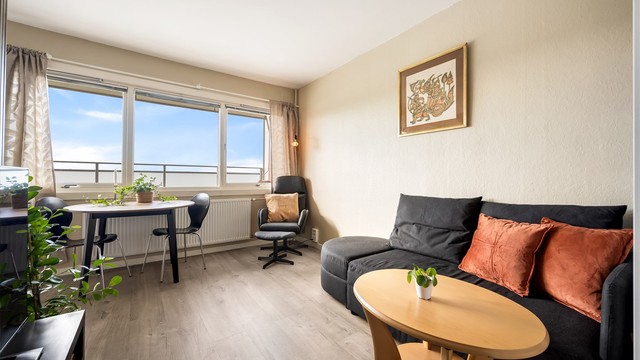 Stuen oppvarmes med radiator tilkoblet felles varmesentral og har plass til både sofagruppe og spisebord.