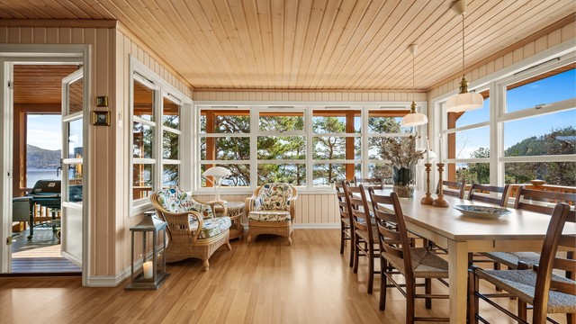 Store vindusflater fra 2002 slipper inn rikelig med dagslys og rammer inn utsikten mot naturen og fjorden.