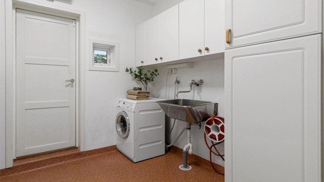 Praktisk vaskerom fra byggeår med utslagsvask og opplegg for vaskemaskin.