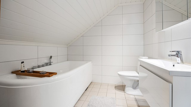 Her er det badekar for ekstra komfort, samt flislagt gulv med varmekabler.