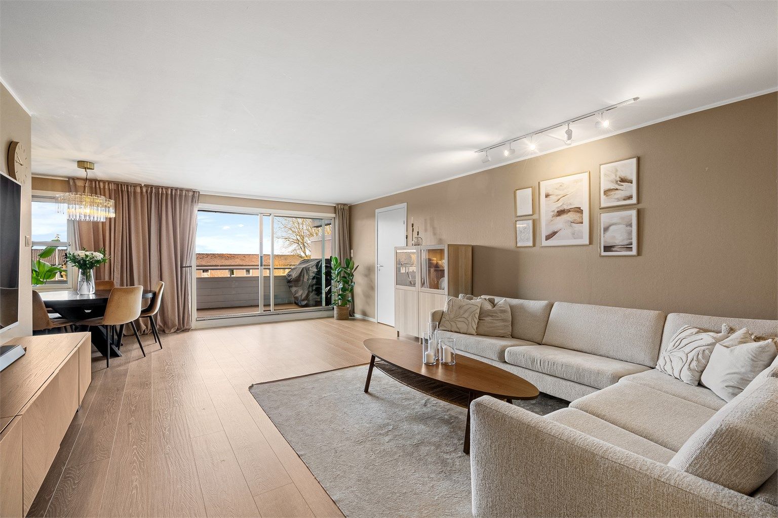 Stor og romslig stue med delvis åpen løsning mot kjøkken, og med utgang til solrik balkong. 