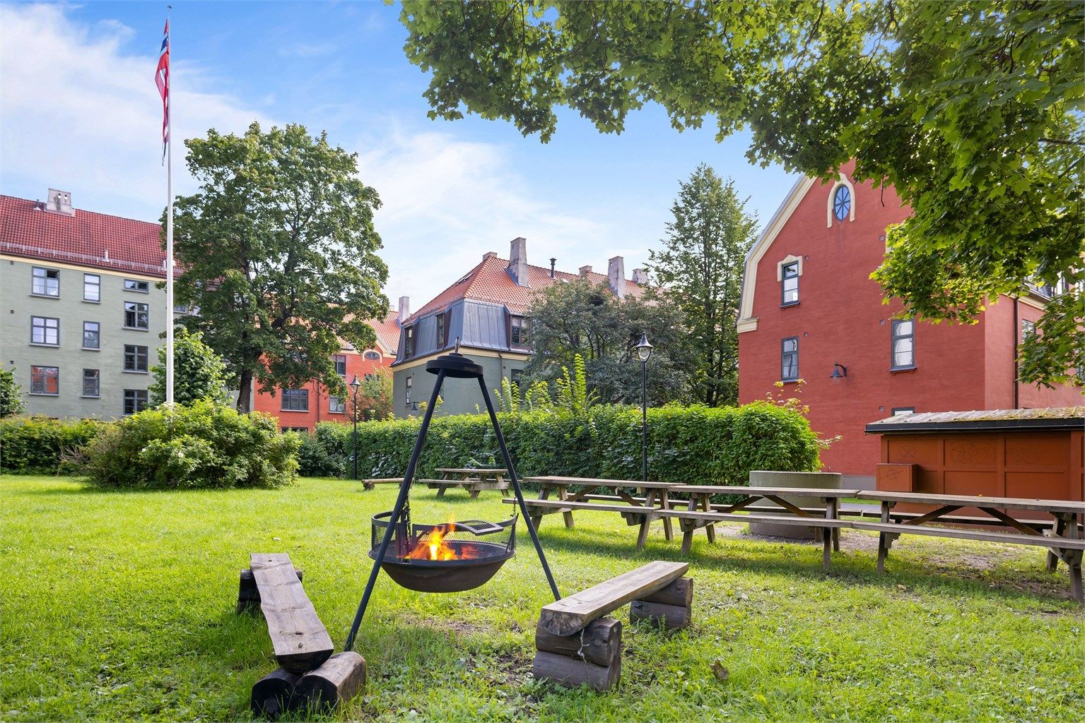 Stor felles park med sittegrupper, grill og bålpanne.