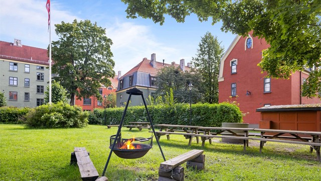 Stor felles park med sittegrupper, grill og bålpanne.