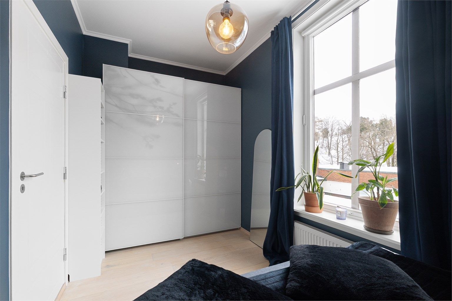Rommet har en praktisk skyvedørsgarderobe.