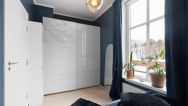 Rommet har en praktisk skyvedørsgarderobe.