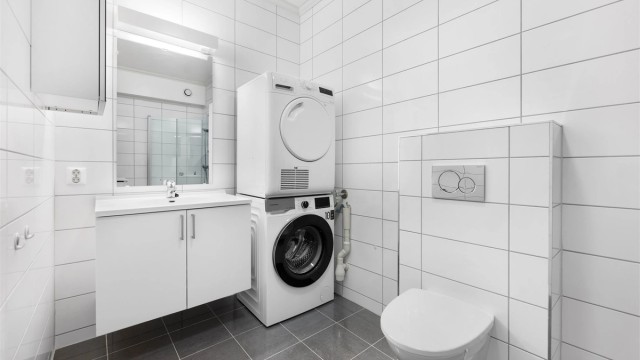 Kjellerleilighet - Badet er helfliset med gulvvarme og innredet med baderomsmøbler, vegghengt wc og dusjhjørne