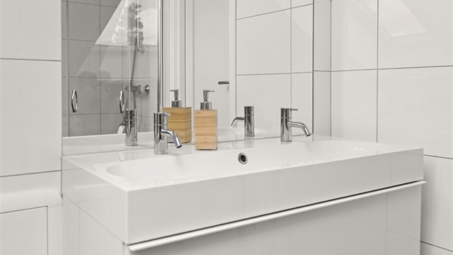 Vegghengt servantinnredning med slette skuffefronter gir et rent uttrykk.