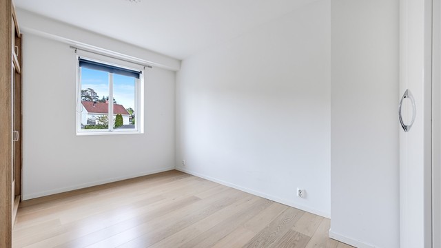 Romslig og delikat soverom med god plass til dobbeltseng og tilhørende møblement.