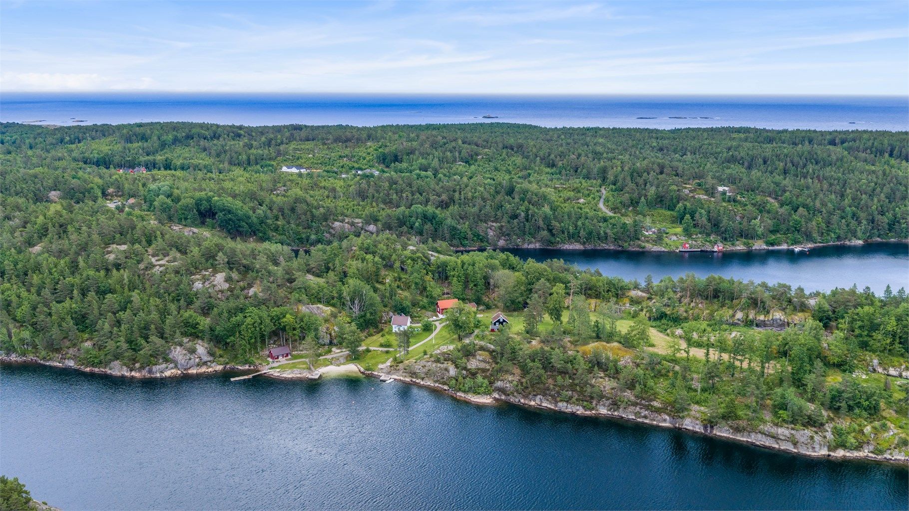 Sett fra luften viser halvøya seg i hele sin utstrekning -  omgitt av vann på alle kanter, med bygningene trygt plassert i det grønne. En sjelden og eksklusiv eiendom i hjertet av Sørlandskysten