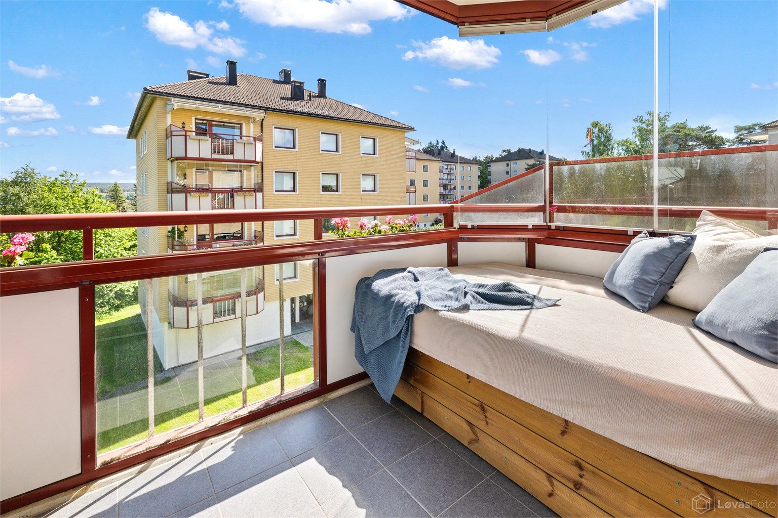 Balkongen er innglasset, noe som forlenger brukstiden gjennom året. Gulvet er belagt med fliser.