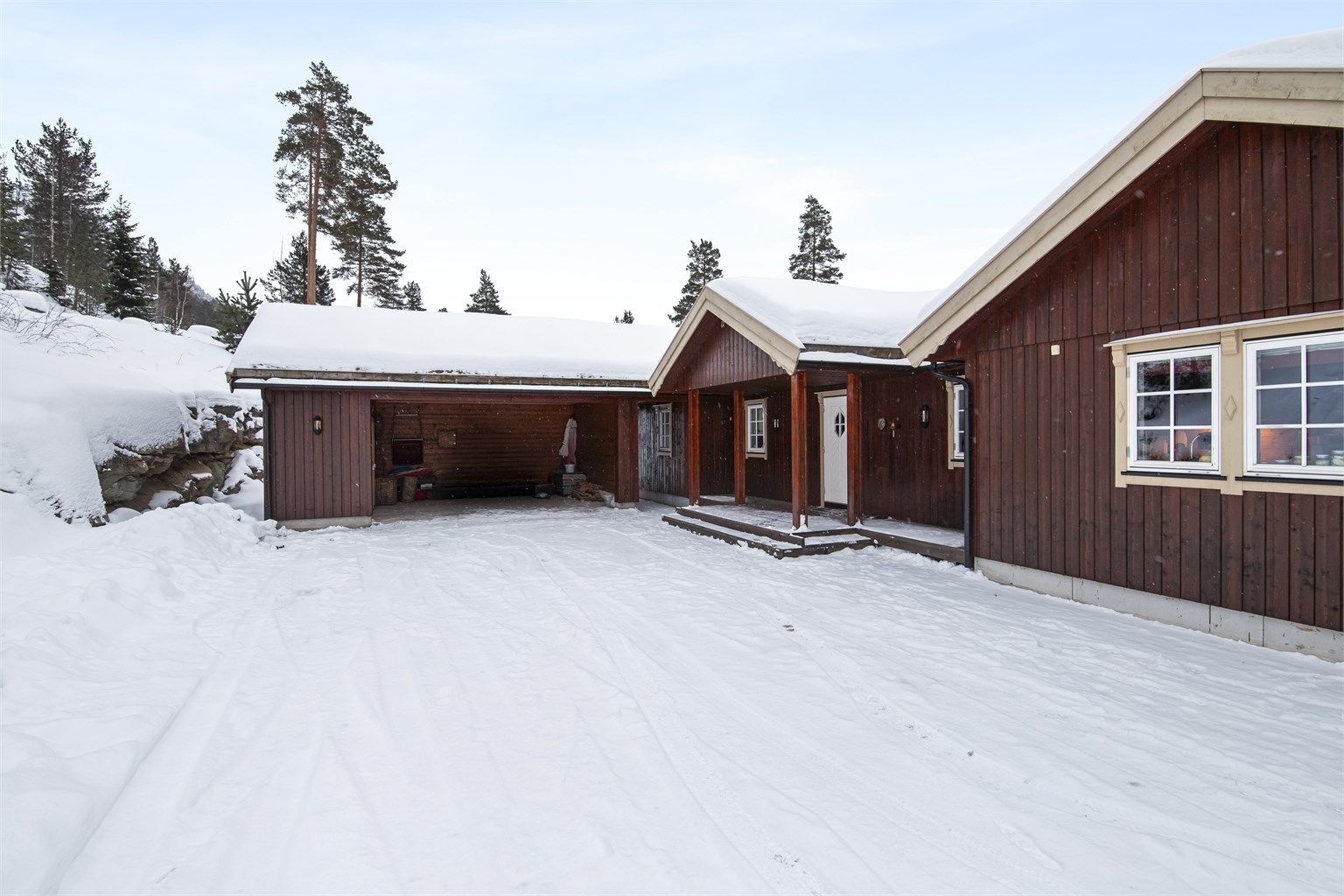 Stor gårdsplass og carport med bod
