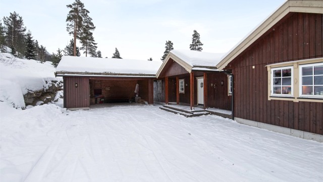 Stor gårdsplass og carport med bod