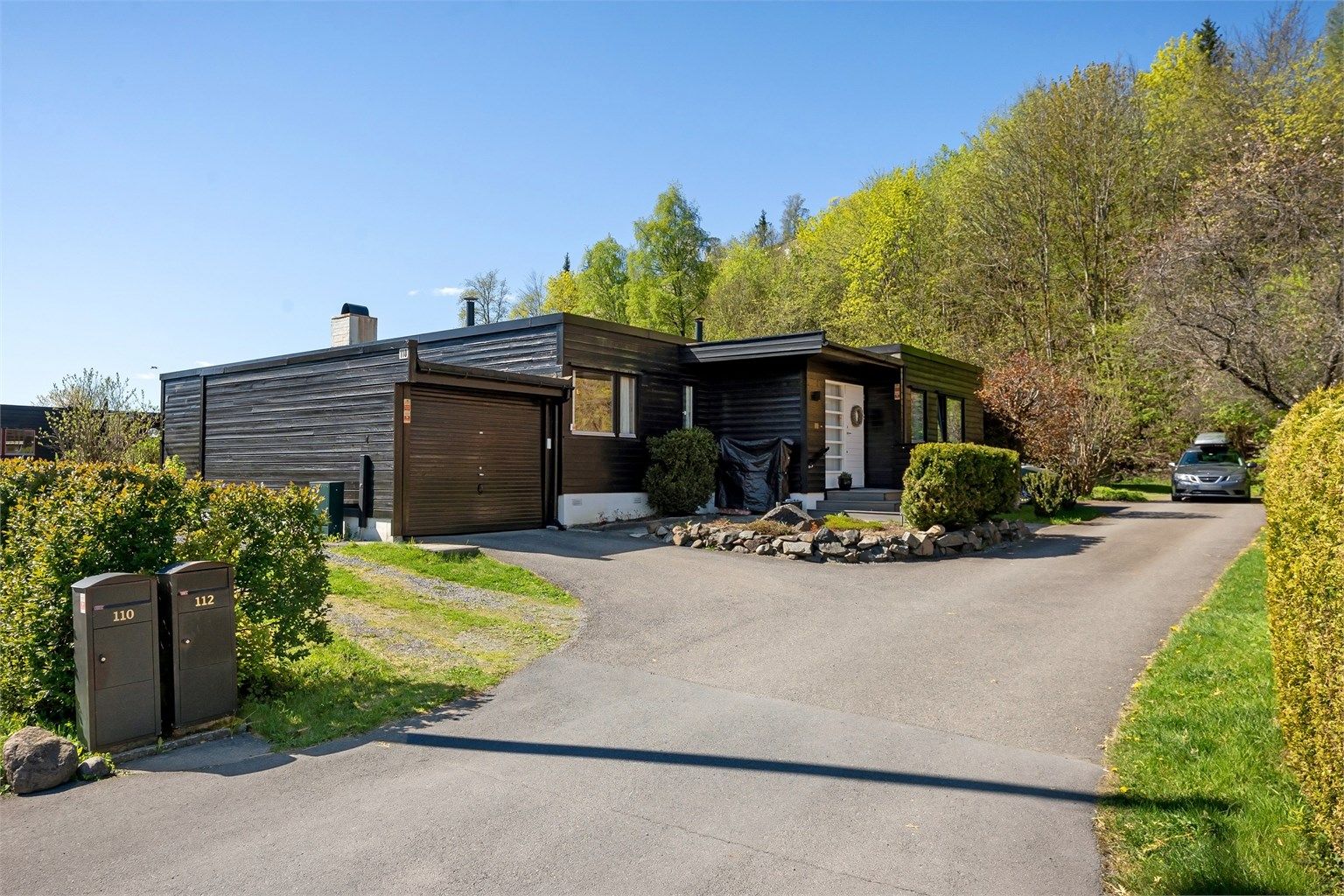Sett fra oppkjørsel. Egen garasje og plass for parkering langs med huset om ønsket.