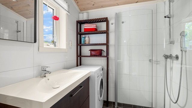 Badet er innredet med servantskap med speil, dusjhjørne, vegghengt toalett og plass til vaskemaskin. Det er også etablert varmekabler på badet.