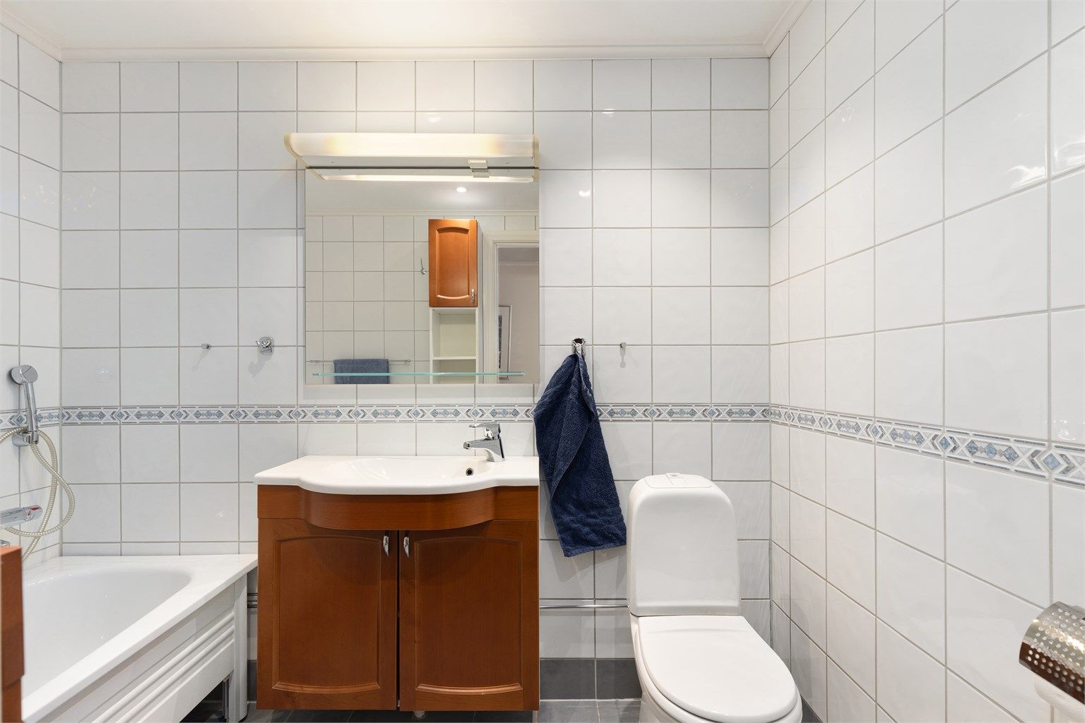 Badet er videre utstyrt med gulvstående WC og godt med oppbevaring i servantskap og veggskap