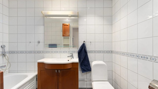 Badet er videre utstyrt med gulvstående WC og godt med oppbevaring i servantskap og veggskap