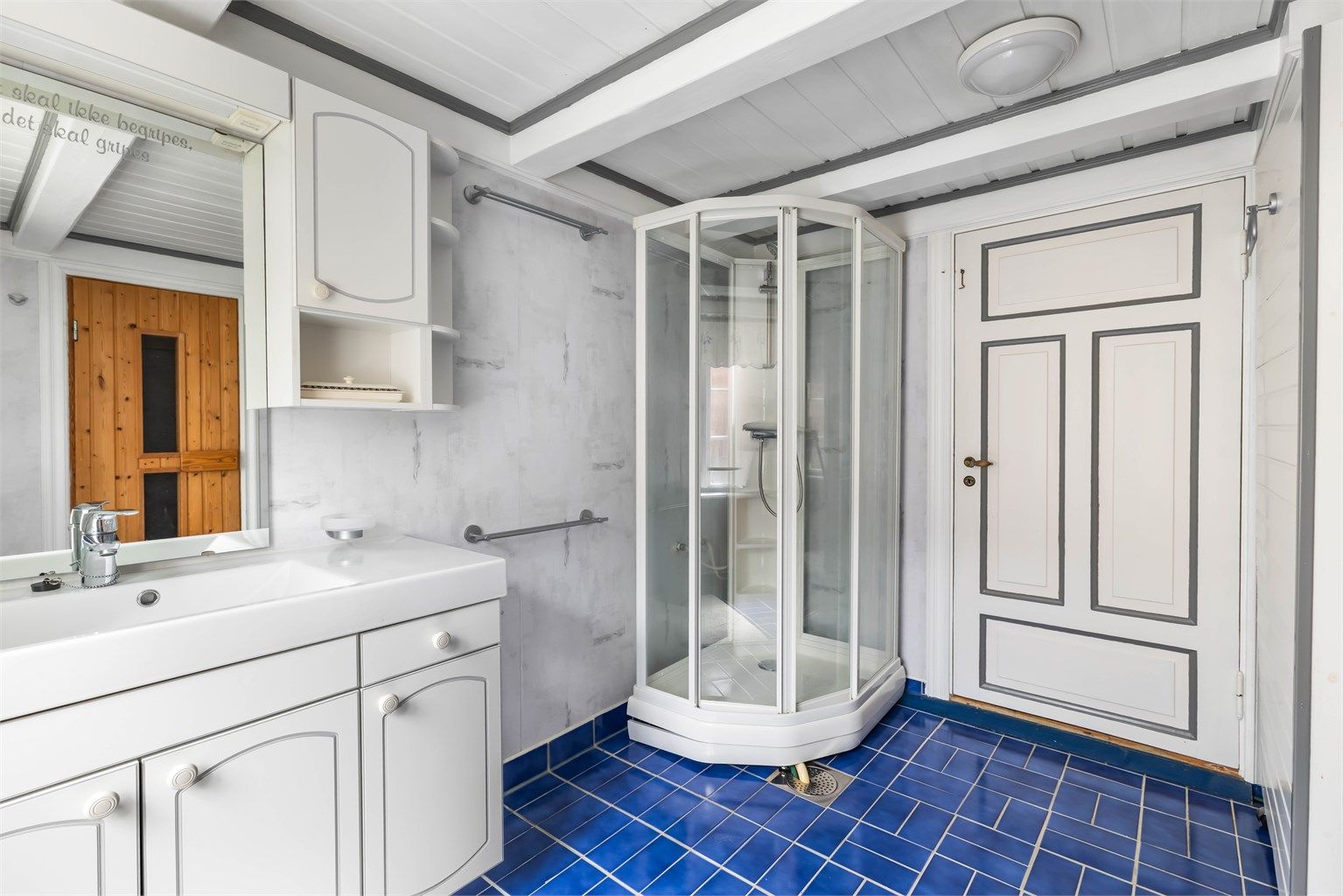 Badet er utstyrt med servantinnredning, toalett, skjult varmtvannstank og dusjkabinett.