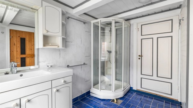 Badet er utstyrt med servantinnredning, toalett, skjult varmtvannstank og dusjkabinett.