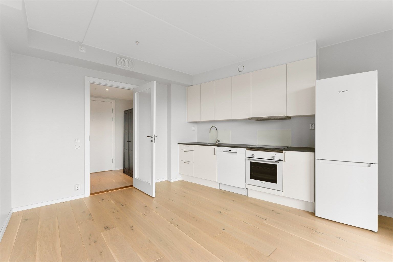 Kjøkkeninnredning fra byggeåret med glatte fronter og laminert benkeplate.