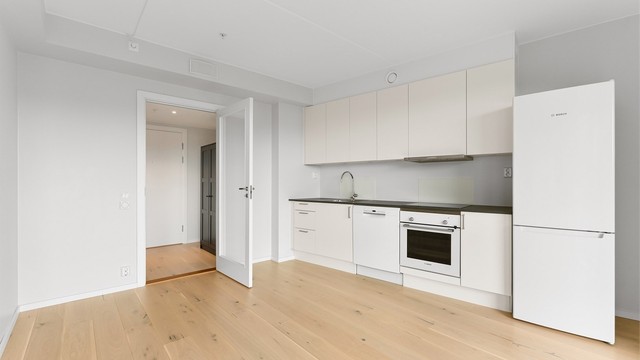 Kjøkkeninnredning fra byggeåret med glatte fronter og laminert benkeplate.