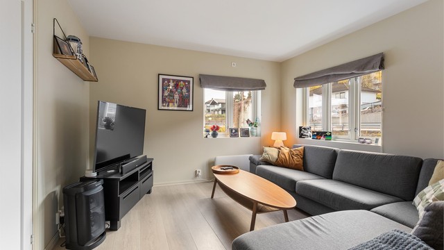 Stuen i andre etasje har plass til en romslig hjørnesofa og nyter godt av lys fra flere vinduer.