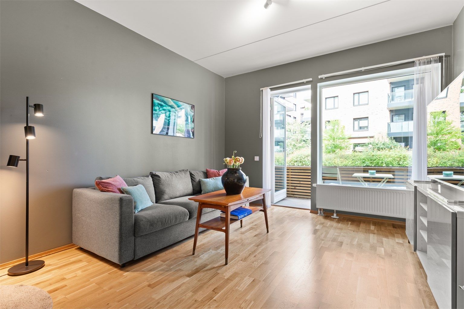 Det er store vindusflater som slipper inn rikelig med lys og som sammen med den gode takhøyden bidrar til å skape en luftig følelse i leiligheten.