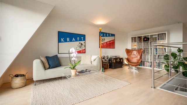 Romslig stue med plass til både sofakrok, bokhyller og lenestol.