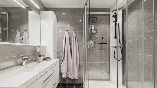 Baderomsinnredning med heldekkende servant, skuffer og innfelte downlights i himling.