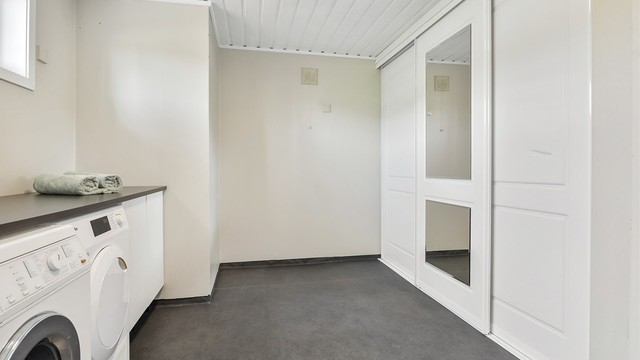 Rommet har opplegg for vaskemaskin/tørketrommel under benk og god lagringsplass i skyvedørsgarderobe.