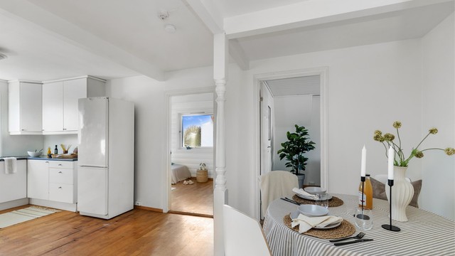 Oversikt fra spiseplassen mot kjøkkenet og tilstøtende soverom.