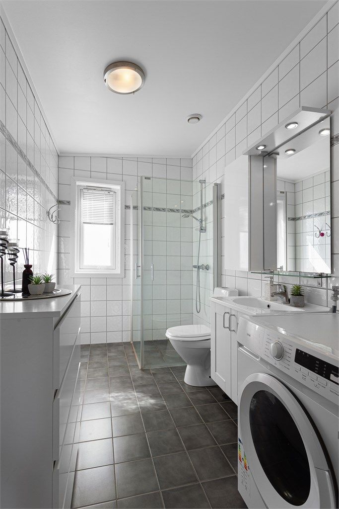 Badet har flislagt gulv med behagelig gulvvarme, dusjhjørne med dører og opplegg for vaskemaskin.