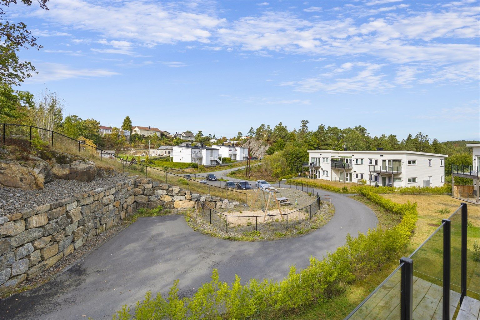Utsyn fra balkongen over fellesområdene og det etablerte boligområdet.