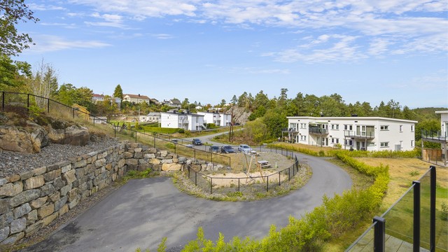 Utsyn fra balkongen over fellesområdene og det etablerte boligområdet.